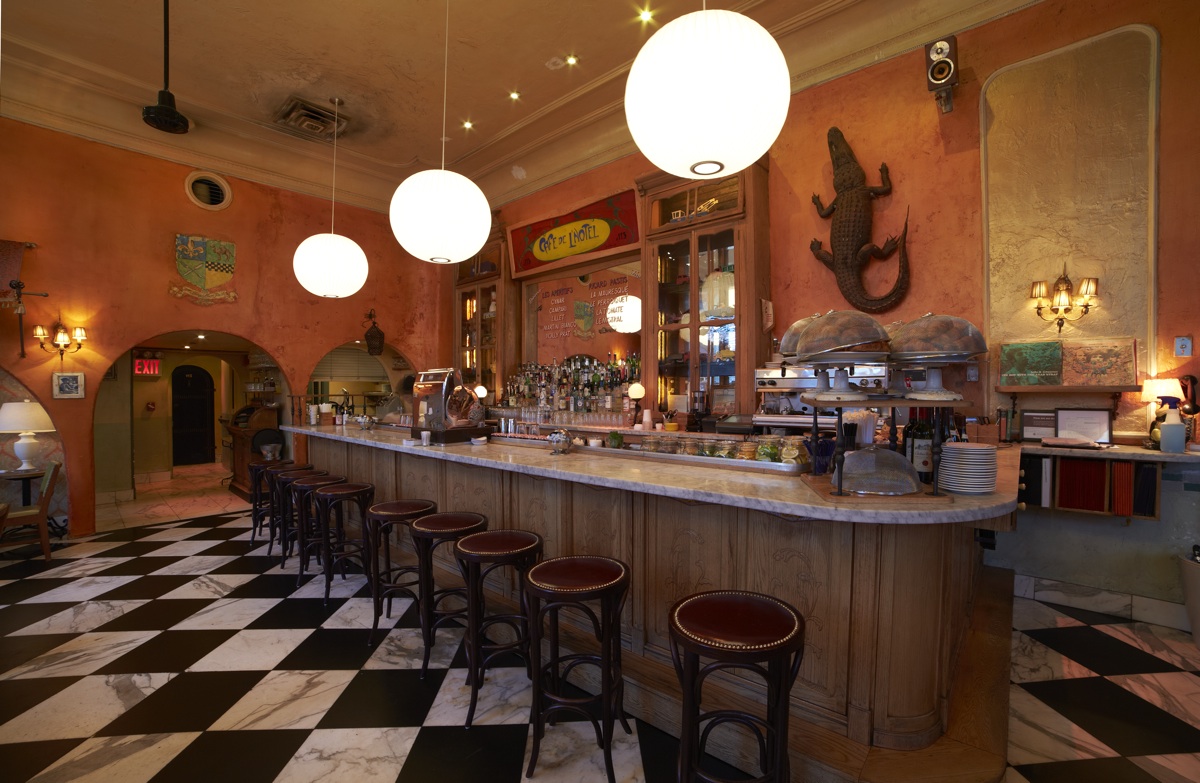 A curved bar counter with stools above a black and white checkerboard floor