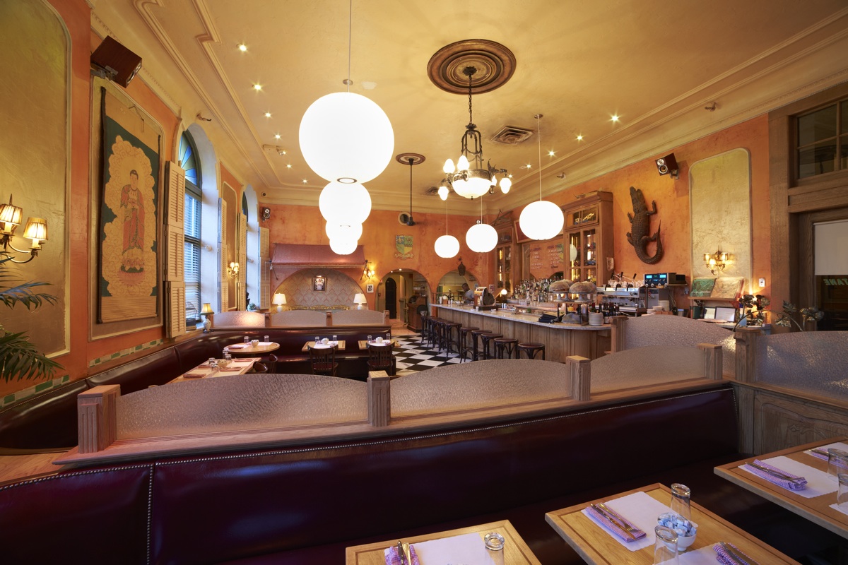 A long dining room lined with globe lights and banquette seating