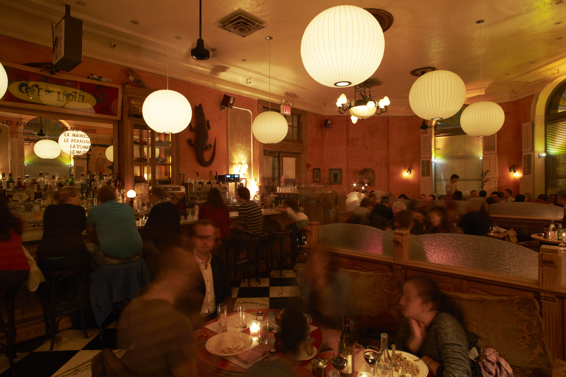 A dining room full of people beneath globe pendant lights