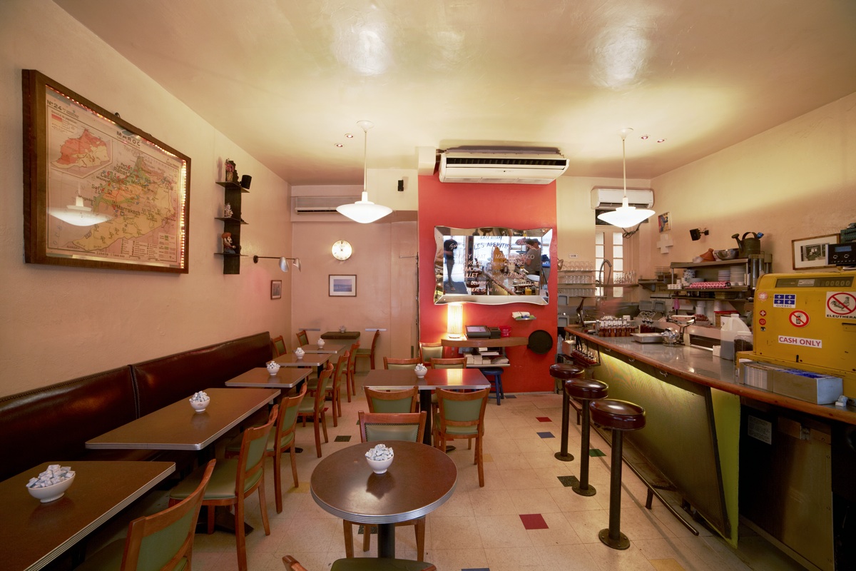 The Cafe Gitane dining room with banquettes, a long counter and pendant lamps