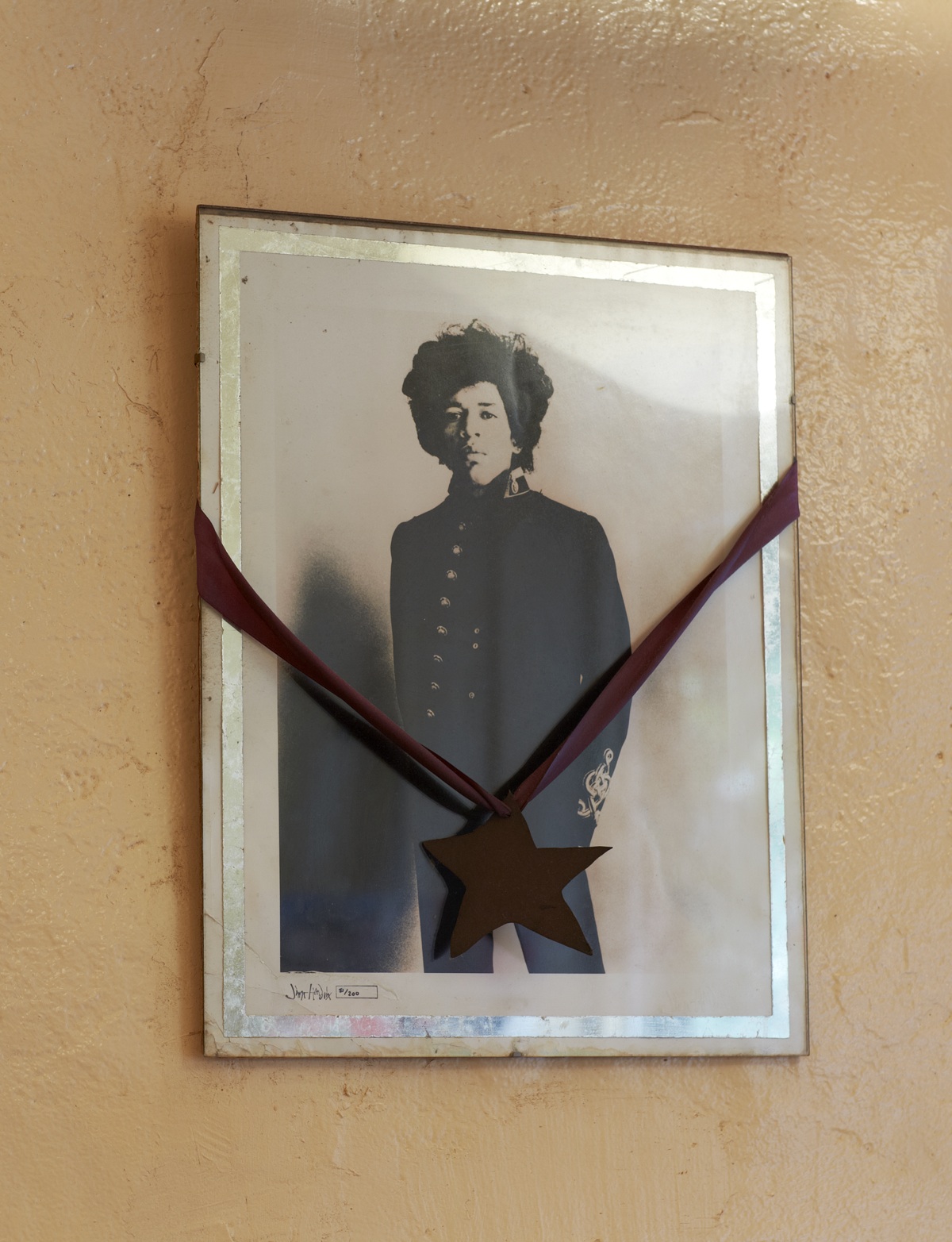 A framed portrait hanging on a plaster wall
